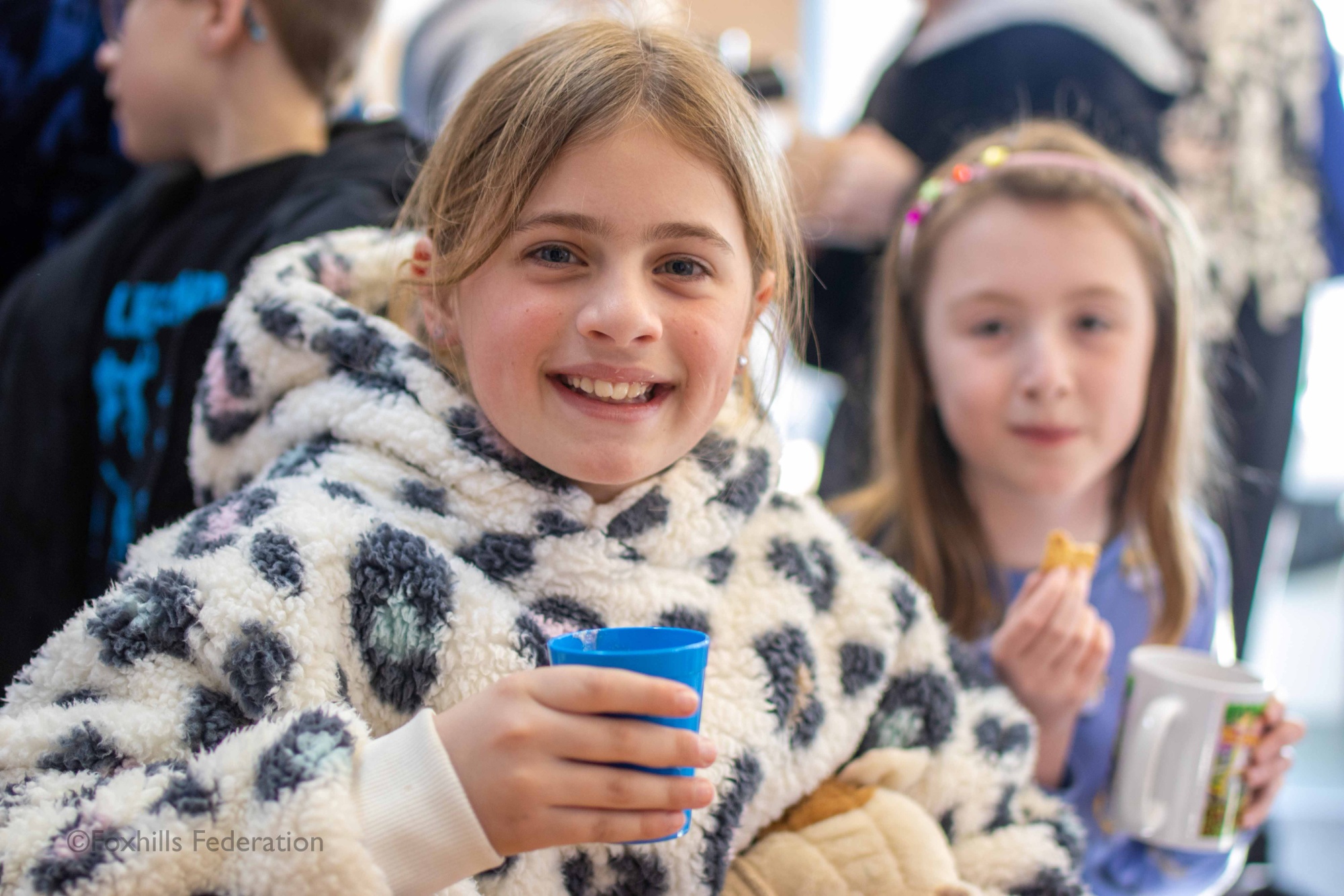 Children eat biscuits while a story is being read to them