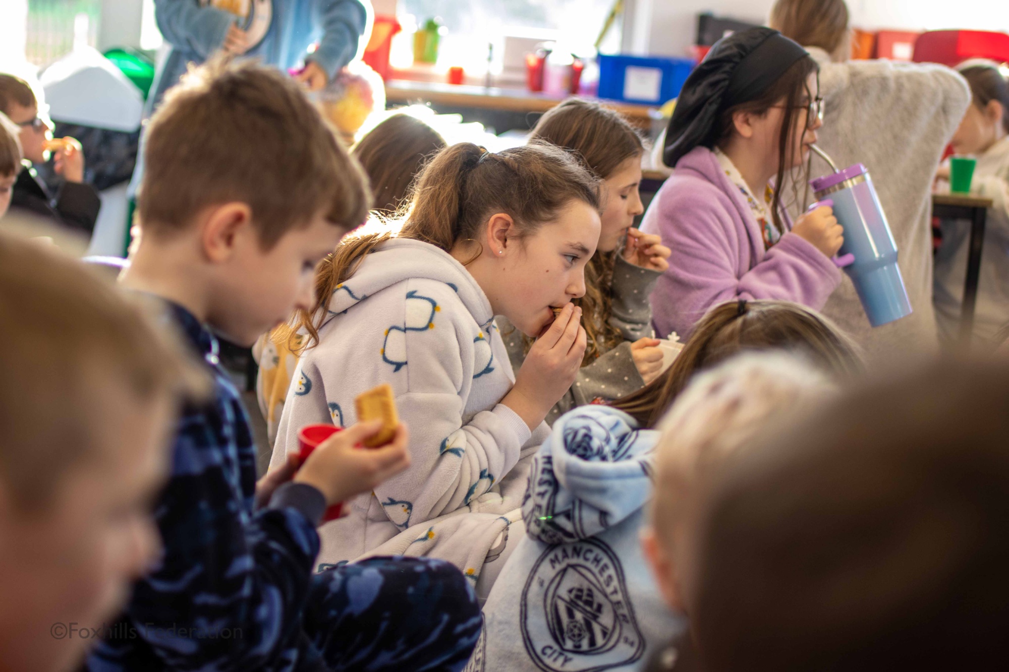 Children eat biscuits while a story is being read to them