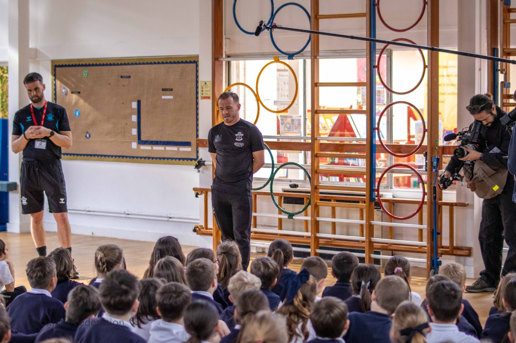 Premier League footballer, Ryan Fraser answers the children’s questions on his career while being filmed by a documentary crew.