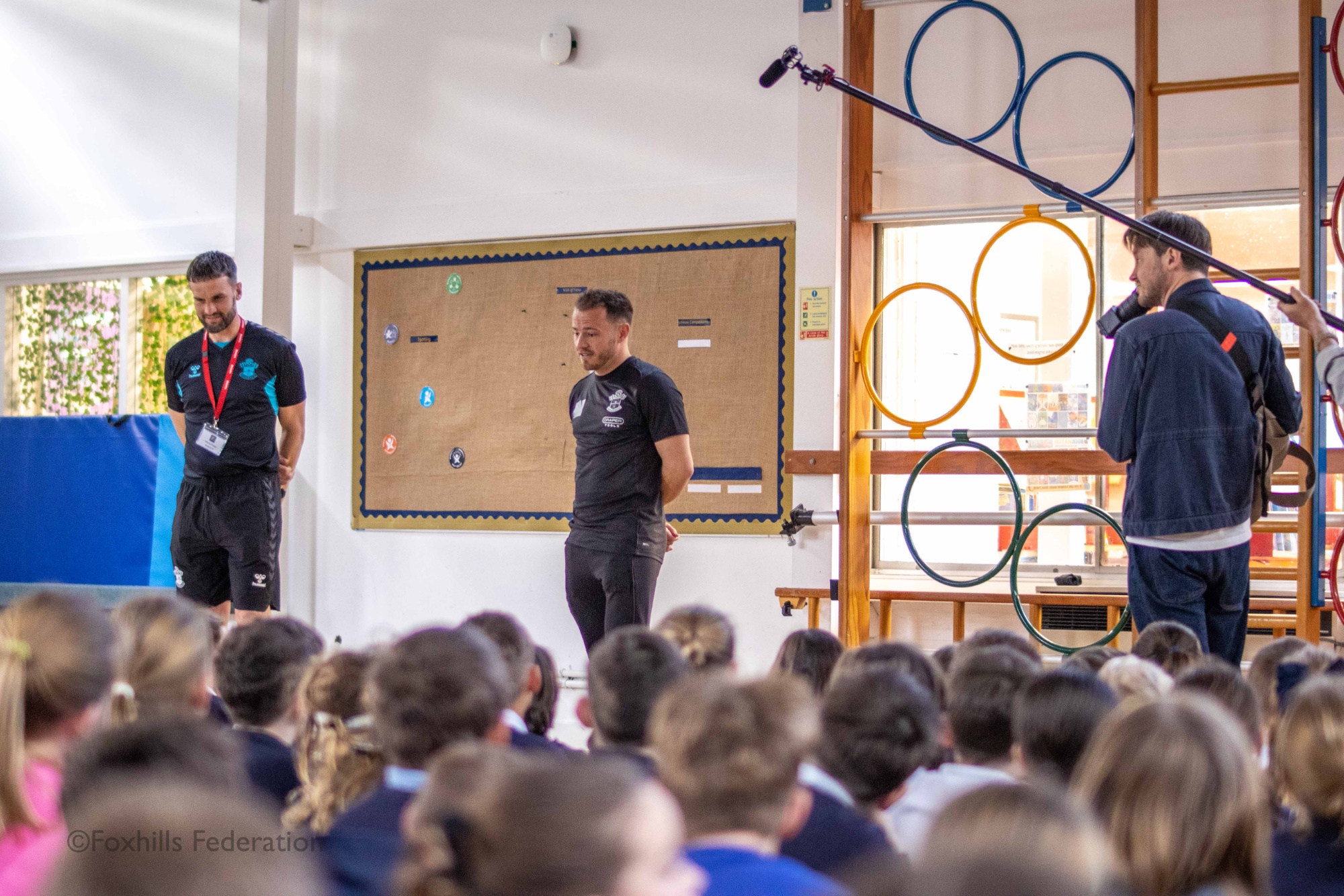 Premier League footballer, Ryan Fraser answers the children’s questions on his career while being filmed by a documentary crew.