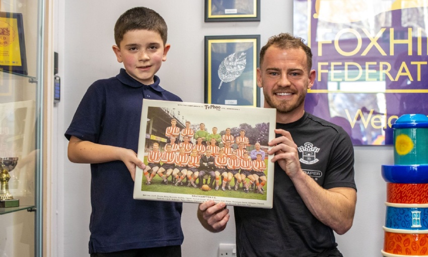 Jacob from Year 4 holding a photo of his great-grandad who played for Southampton F.C and premier league footballer Ryan Fraser.